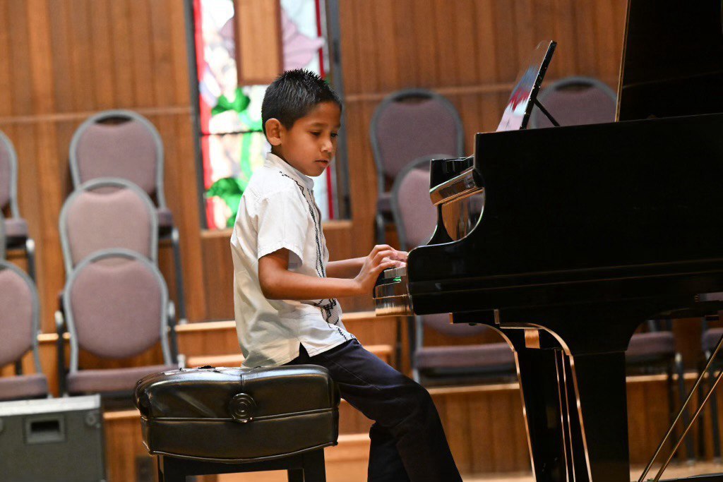 Young pianist performing on a grand piano